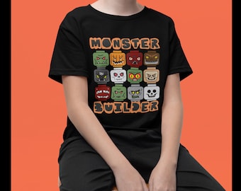 May include: Black t-shirt with the words "MONSTER BUILDER" in orange block letters. The shirt features a grid of colorful monster faces, each with a unique expression. The design is playful and suitable for Halloween or monster-themed events.