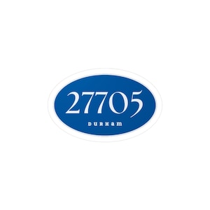 Peut inclure: Un autocollant ovale avec un fond bleu et du texte blanc. Le numéro "27705" est affiché en évidence, avec "DURHAM" écrit en dessous. L'autocollant a une bordure blanche et est placé sur un fond blanc.