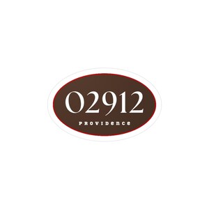 May include: An oval sticker with a brown background and a red border. The number "02912" is in white, bold font. Below the number, the word "PROVIDENCE" is printed in a smaller, white font.