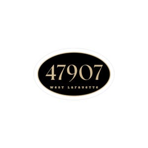 May include: An oval-shaped address plaque with a black background and gold trim. The numbers "47907" are displayed in gold, with "west Lafayette" in smaller gold text below.