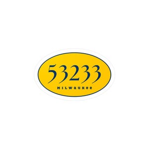 Peut inclure: Un autocollant ovale avec un fond jaune et une bordure bleu marine. L'autocollant présente le numéro "53233" en script bleu marine, avec le mot "MILWAUKEE" imprimé en dessous dans une police bleu marine plus petite.