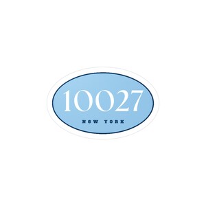 Peut inclure: Autocollant ovale avec un fond bleu clair et une bordure bleu foncé. Le numéro "10027" est imprimé en blanc, avec "NEW YORK" en dessous. L'autocollant est conçu pour être placé sur une surface.