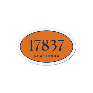 May include: Oval sticker with an orange background, a white border, and the text "17837" in navy blue. Below the numbers, the word "LEWISBURG" is also in navy blue.