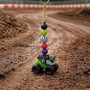 Miniaturowy brelok z Monster Truckiem: torba na pieluchy, zawieszka do wózka i akcesorium do plecaka.