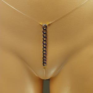 以下が含まれることがあります： 細い透明なコードから吊り下げられた、濃い青色のリンクの垂直チェーンが特徴の繊細なボディチェーン。 チェーンは中央に配置され、垂れ下がり、ミニマリストでモダンな美しさを生み出しています。 チェーンは小さな金色のビーズでコードに接続されています。