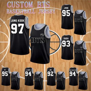 Puede incluir: Camisetas de baloncesto negras con ribetes blancos y números de jugadores. Las camisetas presentan el texto "BTS" y nombres de jugadores como "JUNG KOOK" y "JIMIN". La imagen también incluye el texto "CUSTOM BTS BASKETBALL JERSEY".