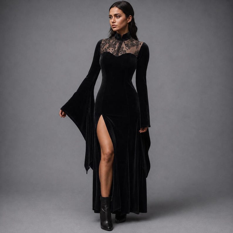 May include: A floor-length black velvet dress featuring long flared sleeves, a high neckline, and a sheer lace panel across the upper chest. The garment includes a fitted bodice and a high side slit that extends from the thigh to the hemline.
