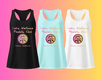 May include: Three tank tops in black, light blue, and white. Each top features the text "Lake Natoma Paddle Club" and a circular graphic with crossed paddles and the number "916". The text "Folsom, California" is below the graphic.
