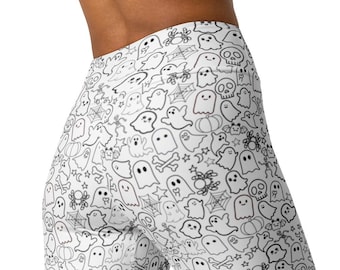 May include: White leggings with a repeating black line art pattern of Halloween-themed ghosts, spiders, cobwebs, pumpkins, and stars. The leggings are form-fitting and made of a stretchy material.