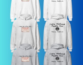 May include: A collection of white and heather gray hooded sweatshirts. The front features the text Meet Me @ The Wire above a Folsom State Prison No Trespassing sign. The back displays Lake Natoma Paddle Club with a circular logo and Folsom, California.