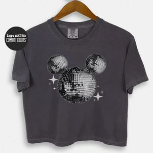 A gray t-shirt with a graphic design of three disco balls and stars on the front.
