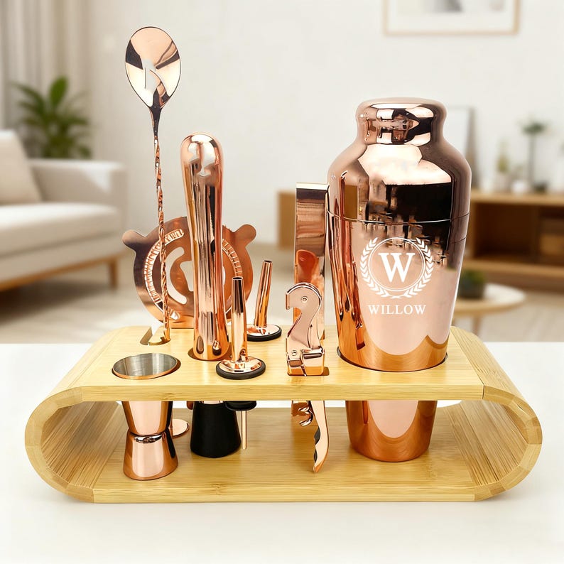 Puede incluir: Un juego de herramientas de bar de oro rosa con una bandeja de bamb&uacute;. El juego incluye una coctelera con el nombre "Willow", un jigger, un colador, un mortero, una cuchara de bar y otras herramientas. Las herramientas est&aacute;n dispuestas en una bandeja de bamb&uacute; marr&oacute;n claro.