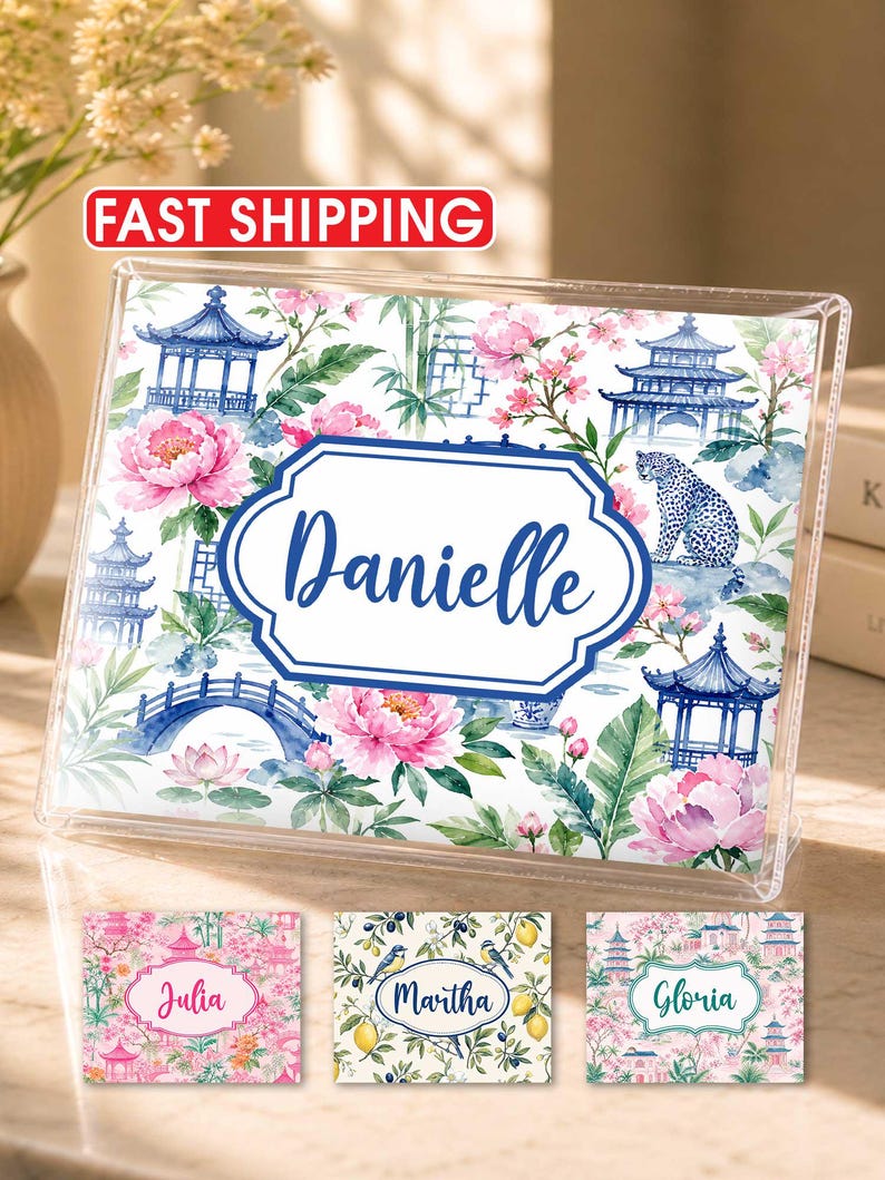 May include: A clear acrylic photo frame with a floral and pagoda design. The frame features the name "Danielle" in a blue, decorative font. Additional name tags with floral designs are also visible. The words "Fast Shipping" are in a red oval.