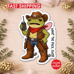 May include: A sticker or magnet featuring a cartoon frog dressed as a cowboy, complete with a hat, vest, boots, and a walkie-talkie. The frog has a red bandana and a pink wing. Text on the sticker reads "WHAT THE FUCK, OVER."