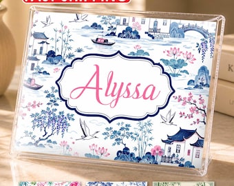 May include: A clear acrylic frame displaying a rectangular print with a blue and white chinoiserie pattern featuring pagodas, boats, and cranes. The center has a decorative label with the name Alyssa in pink script. Three smaller sample prints are below.