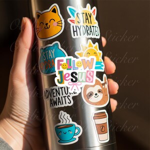May include: A collection of colorful stickers on a stainless steel water bottle. The stickers feature various designs, including a smiling cat, a sun, a sloth, a coffee cup, and the phrases "Stay Hydrated," "Follow Jesus," and "Adventure Awaits."