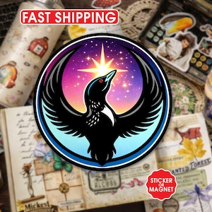 May include: A round sticker or magnet featuring a stylized black bird with outstretched wings against a vibrant, colorful background of purple, pink, and blue. The bird is set within a blue and black border, with a bright starburst above its head.
