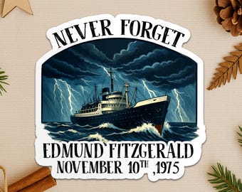 May include: A sticker featuring a dark blue ship sailing through stormy waters with lightning. The text "NEVER FORGET" arches above the ship, and "EDMUND FITZGERALD NOVEMBER 10TH, 1975" is below. The sticker has a white border.