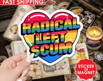 May include: A heart-shaped sticker or magnet with a rainbow gradient design. The text "RADICAL LEFT SCUM" is displayed in bold, multi-colored letters. The sticker is surrounded by a white border and has a glossy finish. The background includes a laptop, candle, and other decorative items.