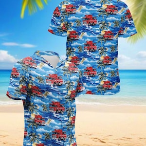 May include: A short-sleeved button-down shirt with a blue background featuring a repeating pattern of red fire trucks, palm trees, and ocean waves. The shirt is displayed on a beach setting.