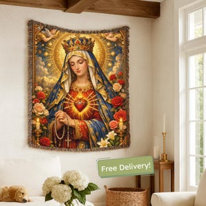 May include: A tapestry featuring a religious figure with a crown, surrounded by roses and angels. The artwork has a heart with rays of light, a rosary, and a blue and red colour scheme. The tapestry is rectangular with a fringed border.