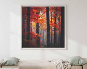 Può includere: Una stampa d'arte da parete quadrata che raffigura una fitta scena boschiva in autunno. La composizione mostra alti tronchi d'albero scuri intervallati da un fogliame vibrante nei toni del rosso fuoco, arancione e giallo oro, in una cornice bianca.