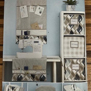May include: Simplicity sewing pattern S9444 for home organization accessories. Includes instructions for a wall organizer, storage bins labeled Fabrics, Patterns, and Notions, a sewing machine cover, a rectangular pillow, and an ironing board cover.