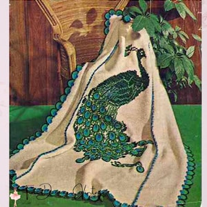 May include: A cream-colored throw blanket featuring a large, detailed peacock motif in shades of dark green and teal. The blanket has a scalloped edge trim in matching teal and green tones. The text "Tiny Dancer Vintage" is printed in black script.