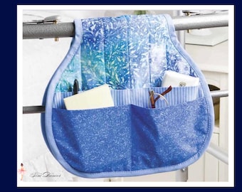 May include: A blue fabric organizer with multiple pockets, hanging from a metal bar. The top section features a blue and white floral pattern, while the pockets are a solid blue. The organizer holds a pen, glasses, and other small items.