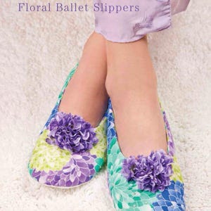 May include: A pair of ballet slippers featuring a vibrant floral pattern in shades of blue, green, and purple. Each slipper is adorned with a large, textured purple fabric flower on the toe. The text "Floral Ballet Slippers" is visible above.