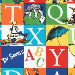 Pode incluir: Tecido colorido com quadrados com letras do alfabeto e ilustrações caprichosas. O design inclui o texto "Dr. Seuss's" e vários personagens de desenhos animados. O fundo é uma colcha de retalhos de cores brilhantes.