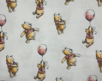 May include: A repeating pattern of Winnie the Pooh bears in various poses, each wearing a red shirt and holding a red balloon. The bears are set against a white background.