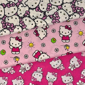 Puede incluir: Tres capas de tela apiladas con estampados de Hello Kitty. La capa superior es blanca con un diseño denso de Hello Kitty. La capa intermedia es rosa claro con Hello Kitty, flores, soles y abejas. La capa inferior es de color rosa oscuro.