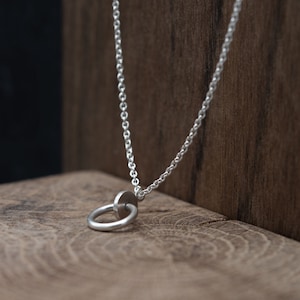 Long silver necklace with circle and dot