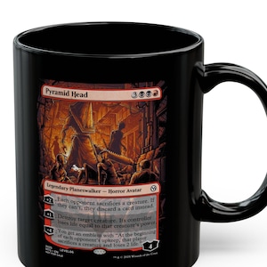 May include: Black ceramic mug featuring a graphic of Pyramid Head, a Legendary Planeswalker Horror Avatar. The artwork is in shades of red, orange, and brown, with text describing the character's abilities. The mug has a curved handle.