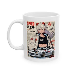 Może przedstawiać: Biały ceramiczny kubek z grafiką postaci w stylu anime z długimi białymi włosami, białą kurtką i czarnym topem. Projekt zawiera biały samochód sportowy i japoński tekst. Kubek ma biały uchwyt.