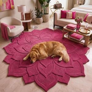 May include: A large, circular, fuchsia-colored area rug featuring a raised, three-dimensional floral petal design that radiates from the center. A golden-brown dog is lying down in the middle of the rug, which is placed on a light-colored floor.