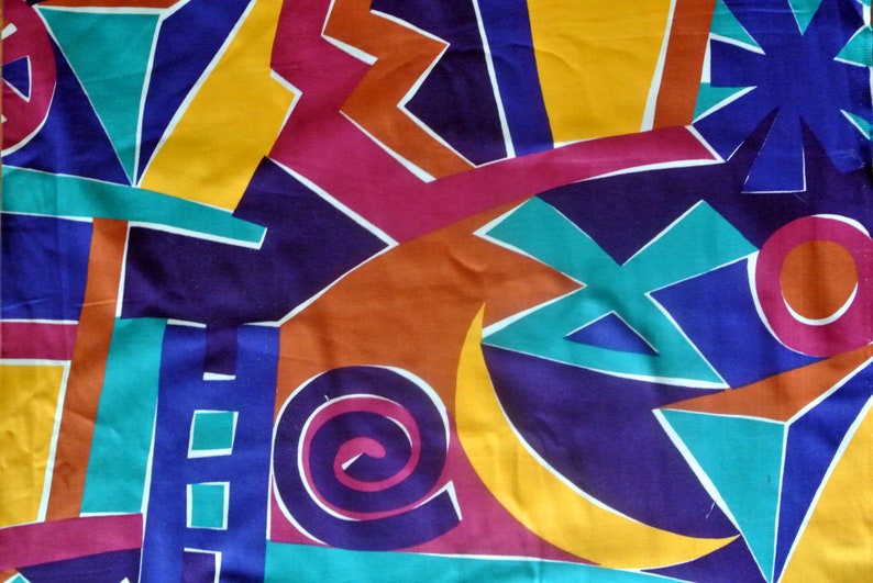 May include: Abstract geometric pattern fabric in shades of blue, yellow, orange, red, and green. The fabric features a variety of shapes, including circles, triangles, and squares.