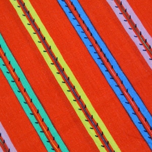 Vintage 1980s fabric in highquality prewashed cotton with larger multicolor printed striped pattern on clear red bottomcolor
