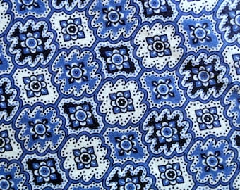 May include: A blue and white patterned fabric with a repeating geometric design. The pattern features small blue and white flowers within a larger diamond shape.