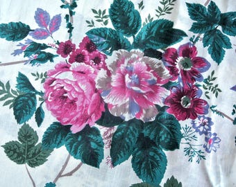 Könnte beinhalten: Ein weißer Stoff mit einem Blumenmuster aus großen rosa und magentafarbenen Rosen, kleineren violetten Blüten und dunkel petrolgrünen Blättern. Das botanische Design ist in einer zentralen Gruppe angeordnet, mit Stielen auf dem weißen Grund.