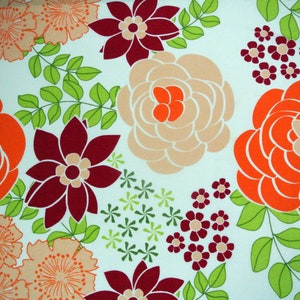 Pode incluir: Um tecido com padrão floral colorido sobre um fundo azul claro. O tecido apresenta grandes flores laranja, pêssego e bordô com folhas verdes.