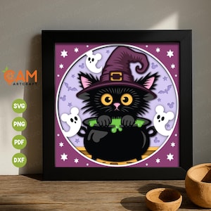 Op de afbeelding: Een ingelijst Halloween-kunstwerk met een zwarte kat met een heksenhoed, die over een borrelende ketel kijkt. Het kunstwerk bevat witte geesten, sterren en vleermuizen tegen een paarse achtergrond. De lijst is zwart.
