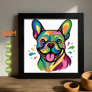 Könnte beinhalten: Ein gerahmter Druck mit einer farbenfrohen Illustration einer Französischen Bulldogge. Das Gesicht des Hundes ist in leuchtenden Farben wie Blau, Grün, Gelb, Rosa und Orange dargestellt. Das Kunstwerk ist vor einem weißen Hintergrund und in Schwarz gerahmt.