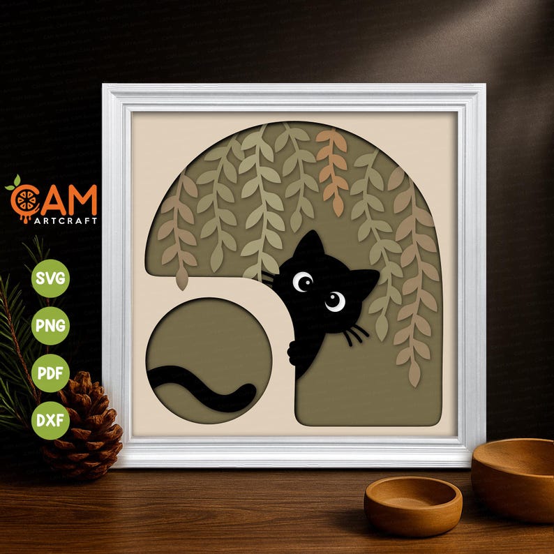May include: A layered paper art piece in a white frame featuring a black cat peeking from behind a curved cutout. The design includes hanging willow-like branches in shades of green and tan against a neutral background, with a cat tail visible.