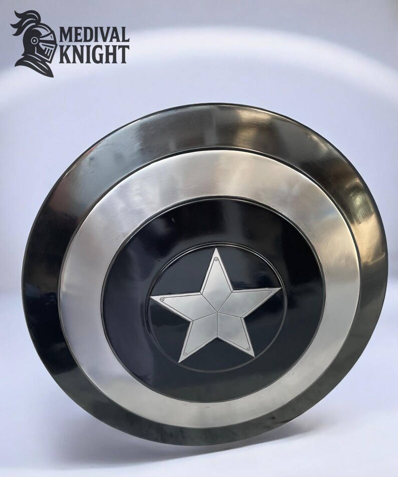 May include: A round, metallic shield with a black center featuring a silver star. The shield has a silver ring and a dark gray outer rim. The text "MEDIVAL KNIGHT" and a knight's helmet logo are in the upper left corner.