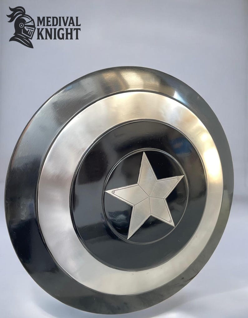 May include: A round, metallic shield with a central star design. The shield features concentric circles in black, silver, and a darker metallic tone. The shield has the text "MEDIVAL KNIGHT" and a knight's helmet logo.