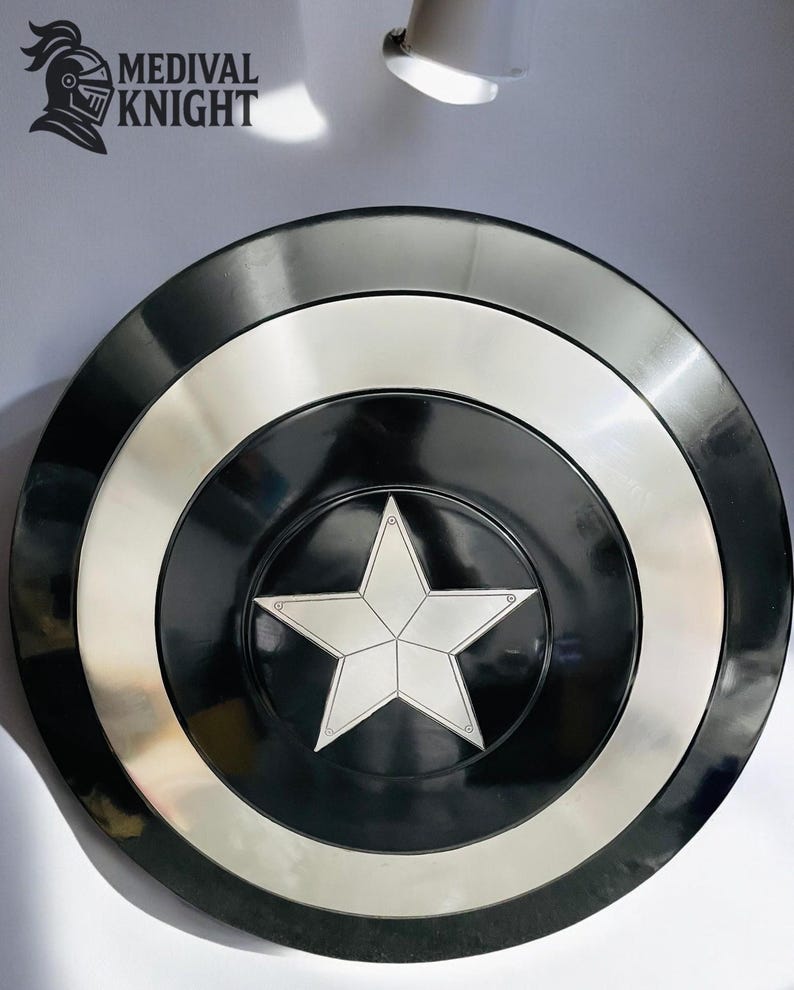 May include: A black and silver shield with a white star in the center. The shield has concentric rings of black, silver, and black. The logo "MEDIVAL KNIGHT" is in the upper left corner.
