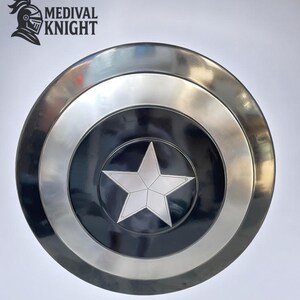 May include: A round, metallic shield with a silver star in the center, set against a black background. The shield has a silver border and a dark outer ring. The logo "MEDIVAL KNIGHT" is in the upper left corner.