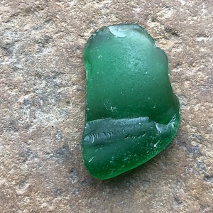 以下が含まれることがあります： 曇ったような外観の滑らかな緑色のシーグラス。海で研磨され、独特な形をしています。